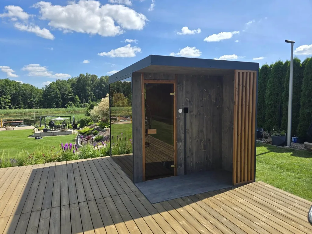 Sauna ogrodowa z panoramicznym przeszkleniem na drewnianym tarasie